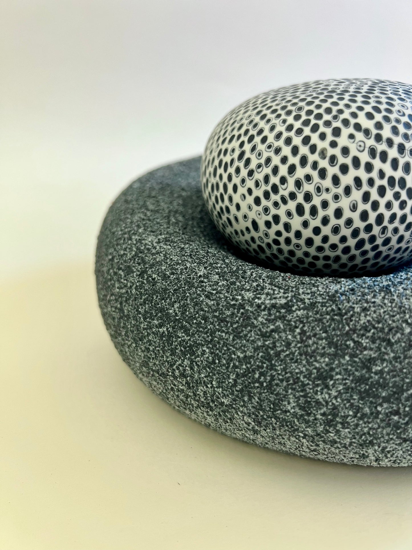 Close-up of the contrast between the rough textured porcelain base and the smooth inlaid porcelain sphere.