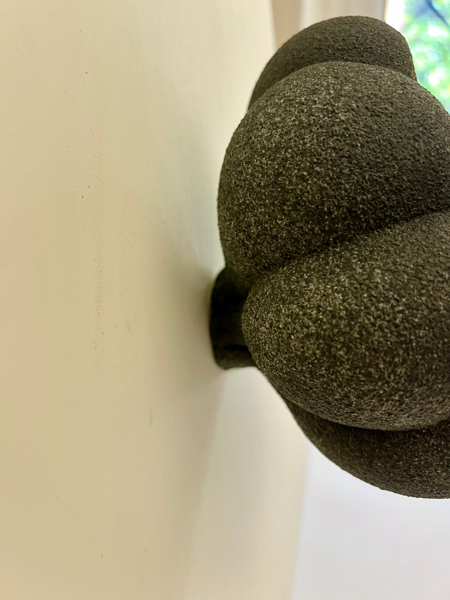 Side view of Crazy Wallflower — Pollen mounted on a wall, showing its sculptural depth and how it sits against the wall
