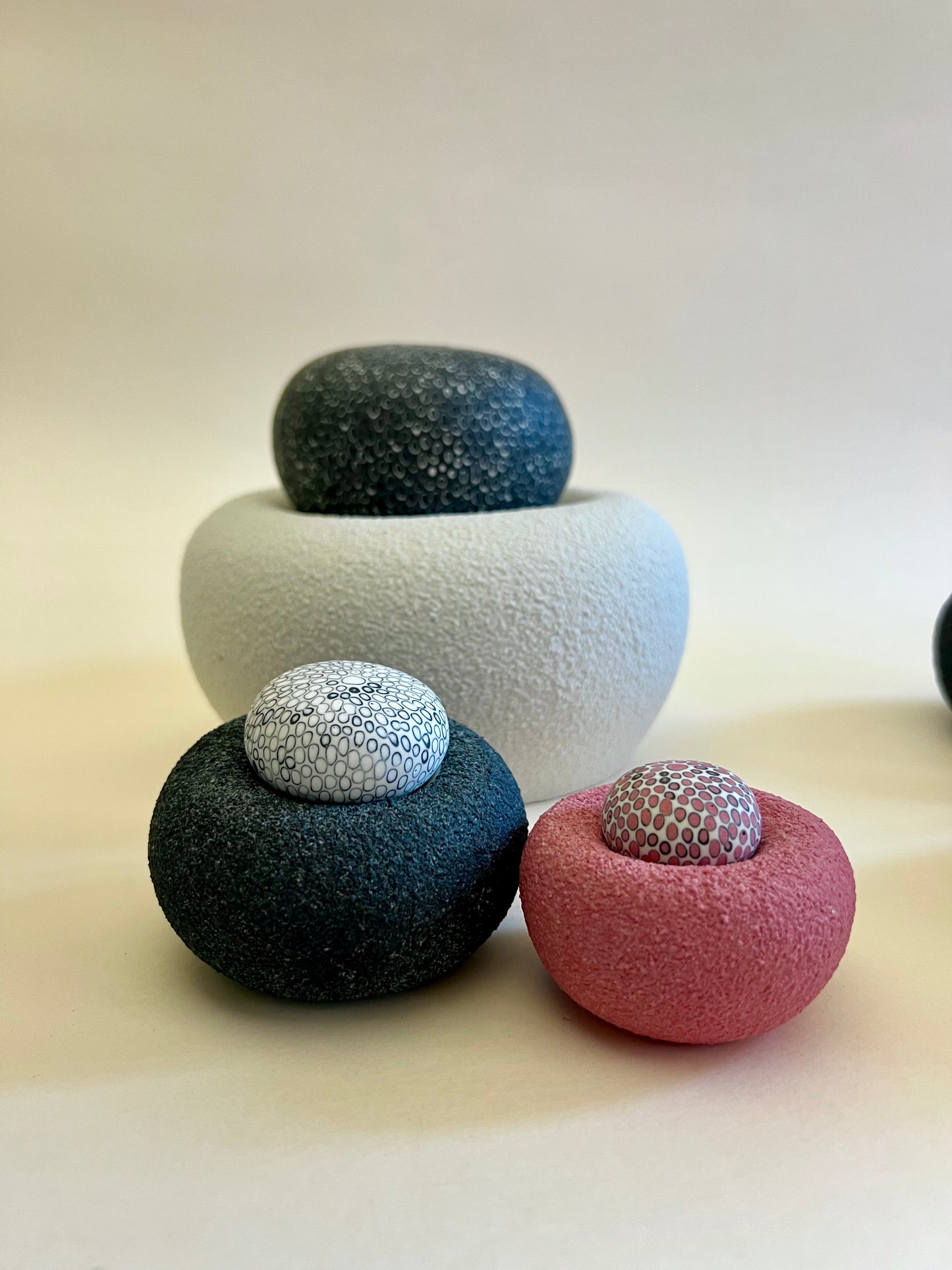 Detail of textured porcelain bases contrasting with smooth inlaid porcelain spheres.