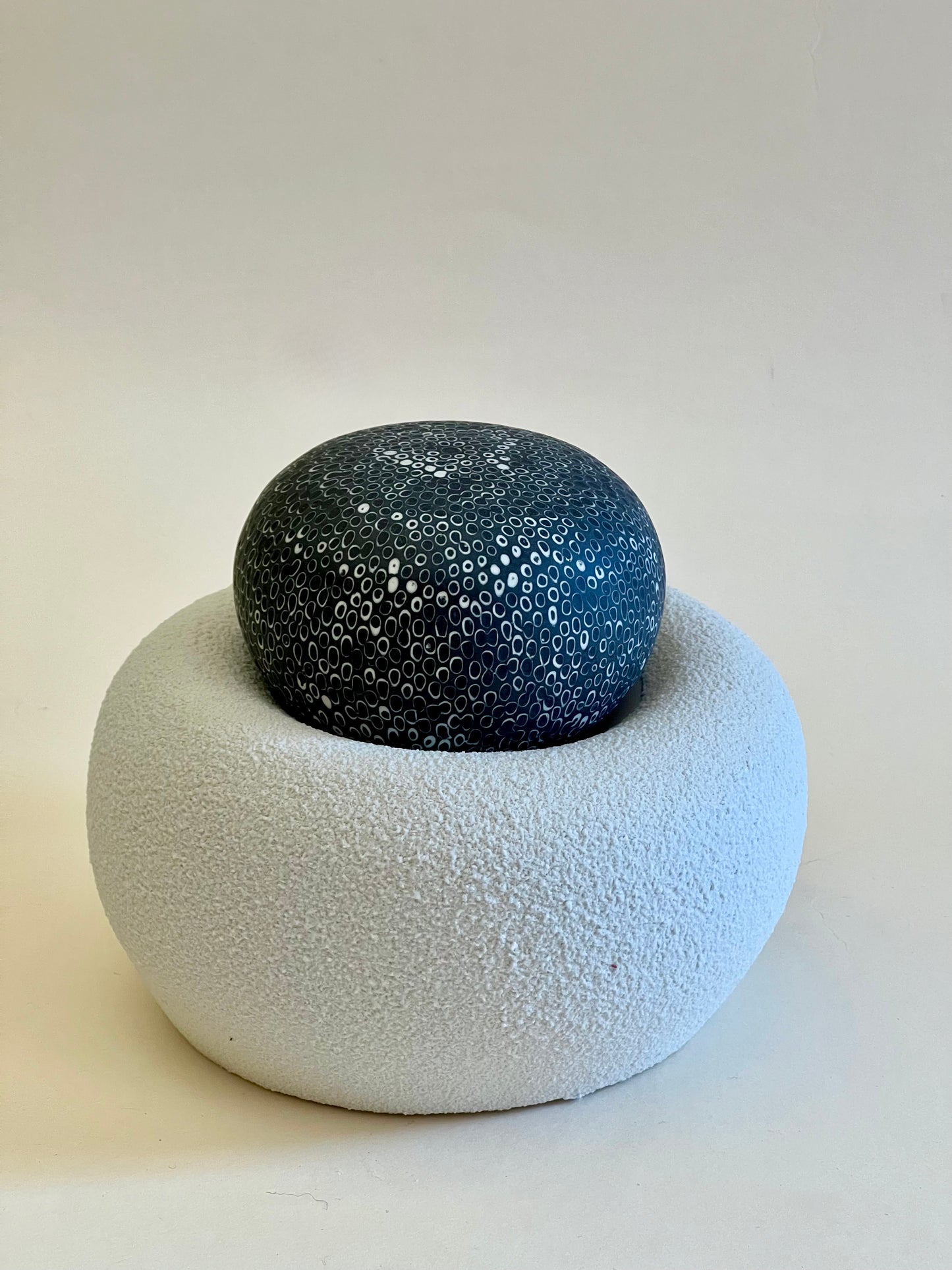 Single handcrafted porcelain sculpture from the Nest II collection with a textured white porcelain base and a black hand-inlaid porcelain sphere.