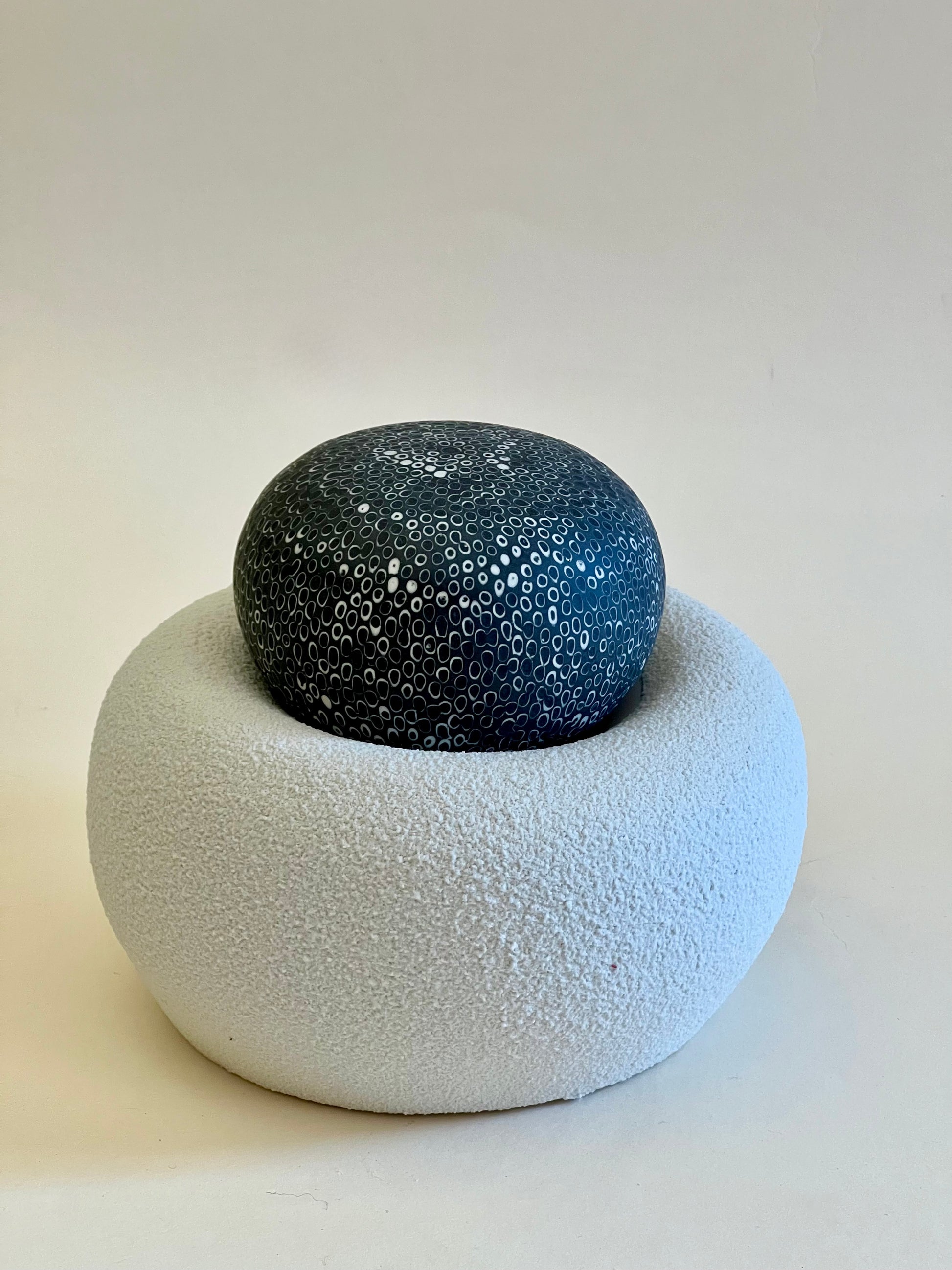 Single handcrafted porcelain sculpture from the Nest II collection with a textured white porcelain base and a black hand-inlaid porcelain sphere.