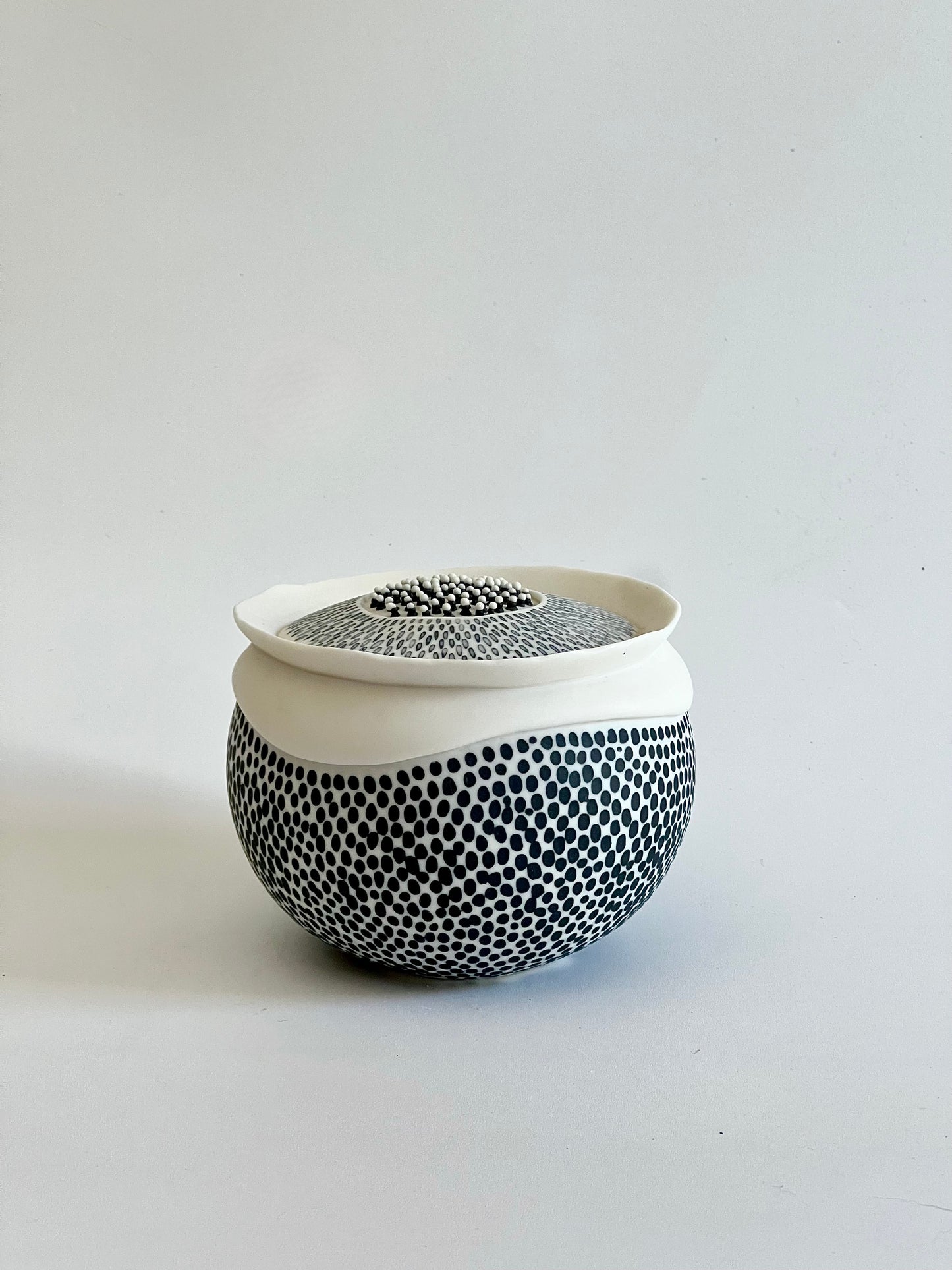 Pulse 1 porcelain sculpture, side three-quarter view, showing its rounded form and black porcelain inlay pattern