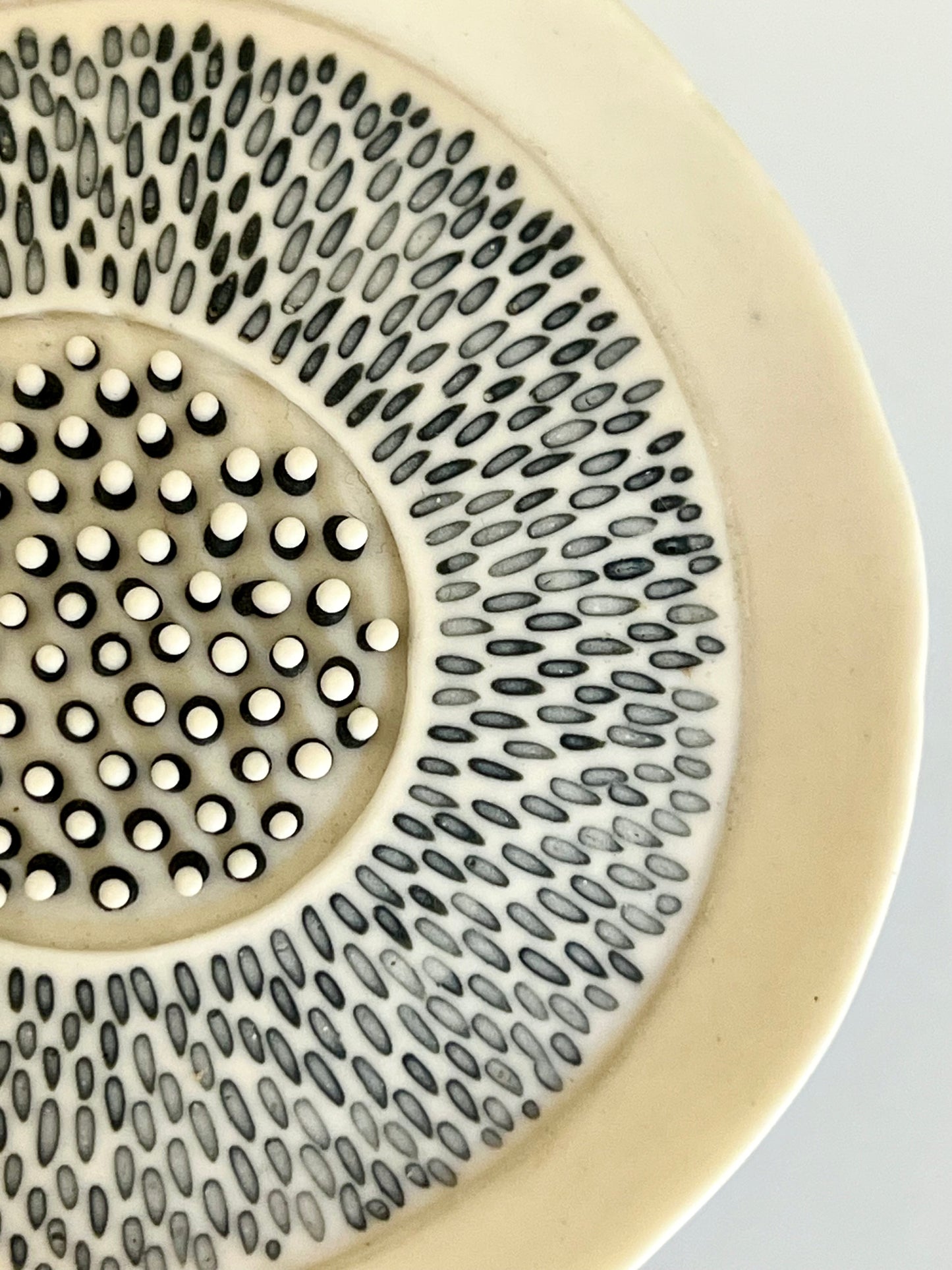 Close-up of Pulse 1 porcelain sculpture showing hand-carved black inlay and raised black and white porcelain drops