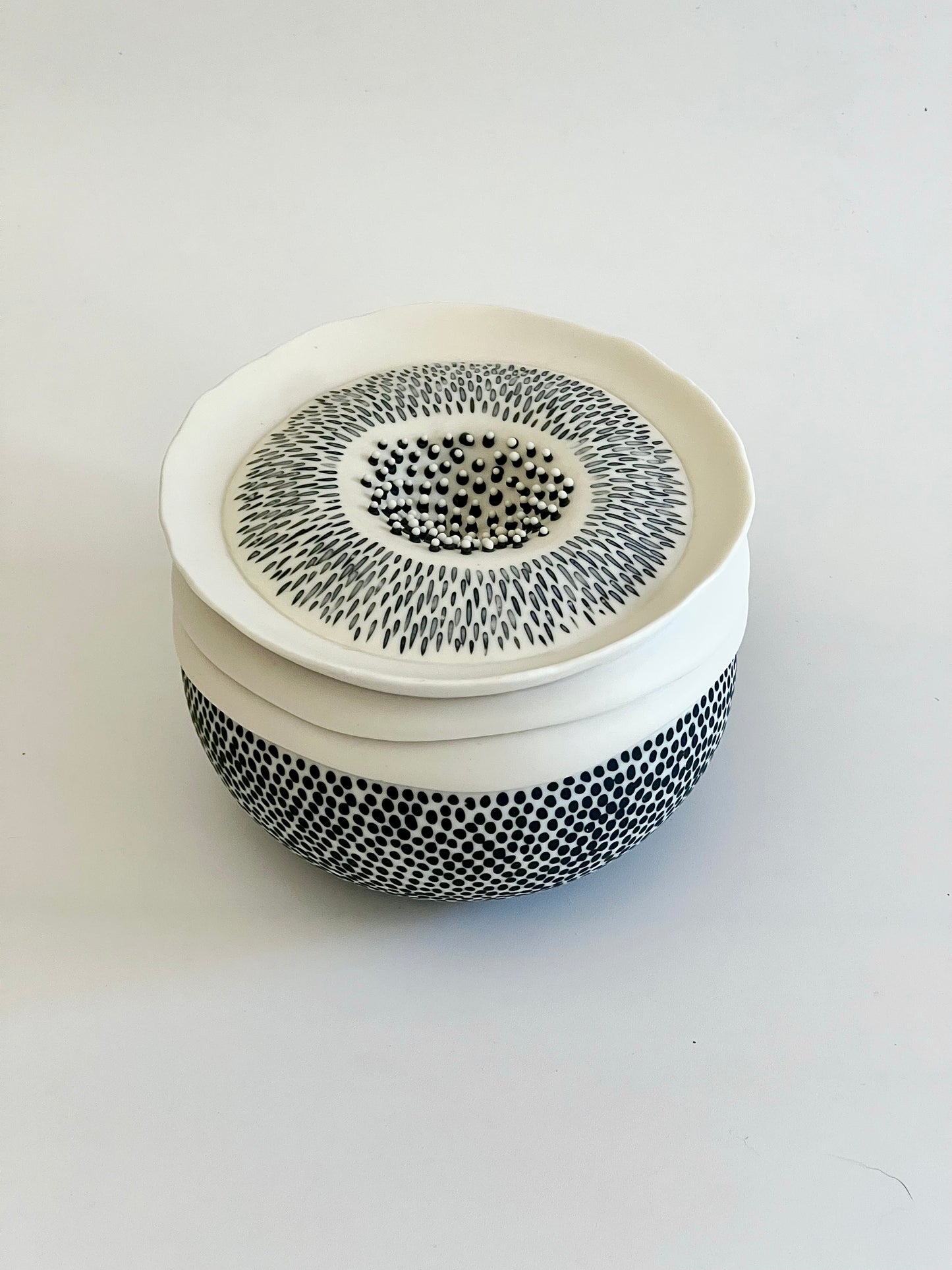 Pulse III white and black porcelain vessel seen from above, showing the slightly recessed upper form, layered rim and textured surface.