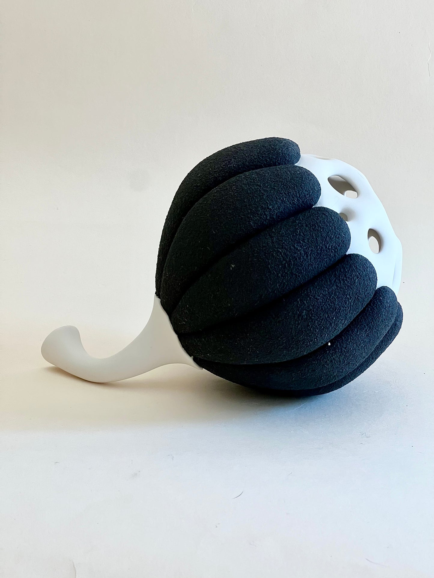 Side view of Seed Pod II handmade porcelain sculpture with curved white stem.