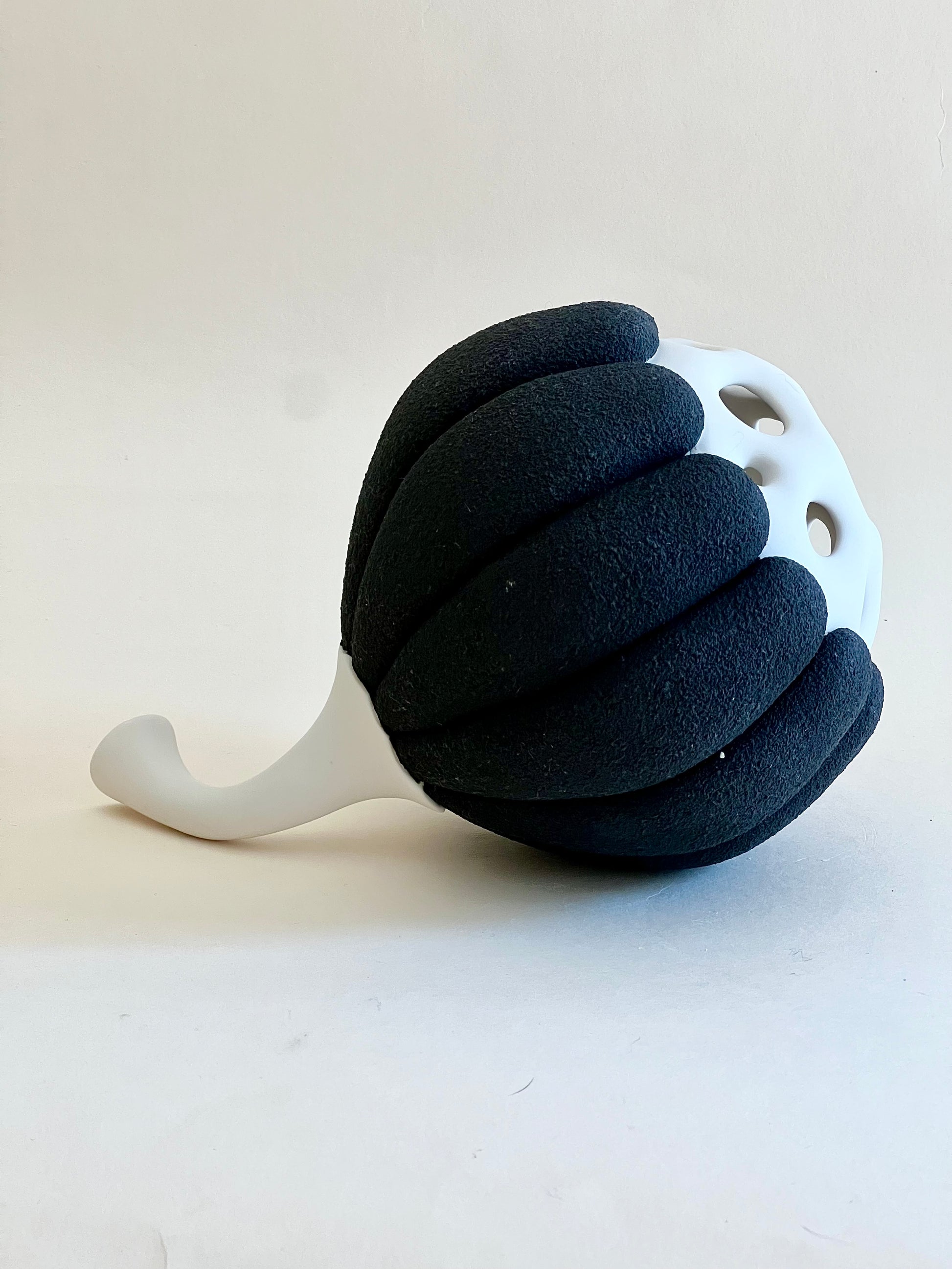 Side view of Seed Pod II handmade porcelain sculpture with curved white stem.