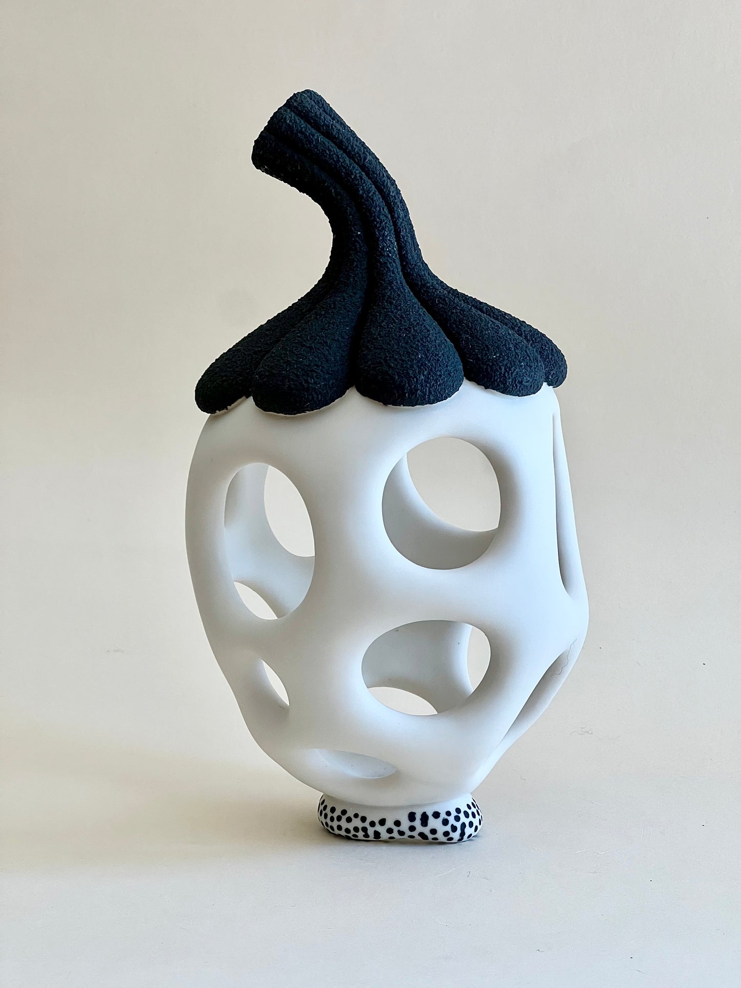 Contemporary porcelain sculpture inspired by seed forms with openwork body.