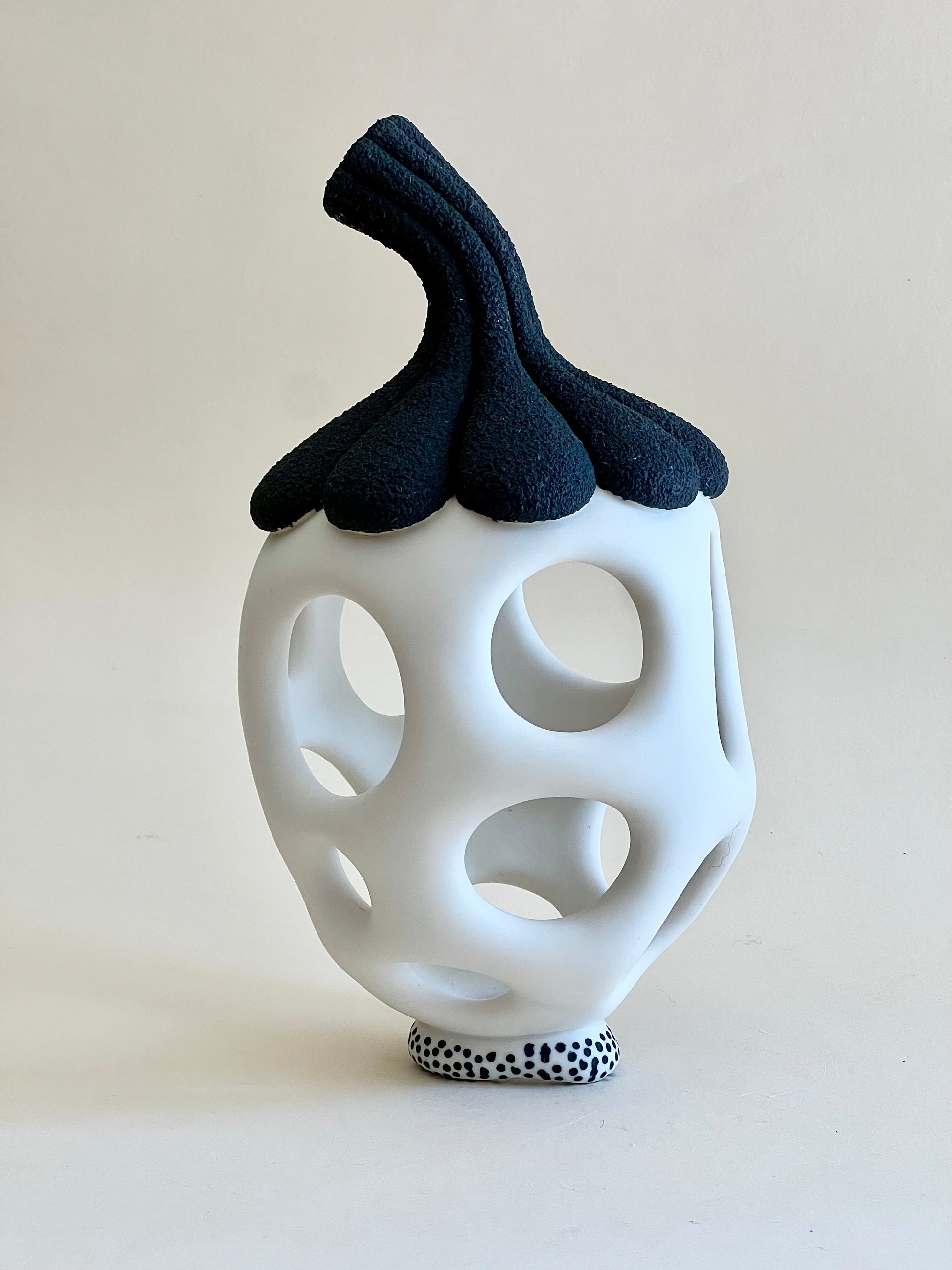 Contemporary porcelain sculpture inspired by seed forms with openwork body.