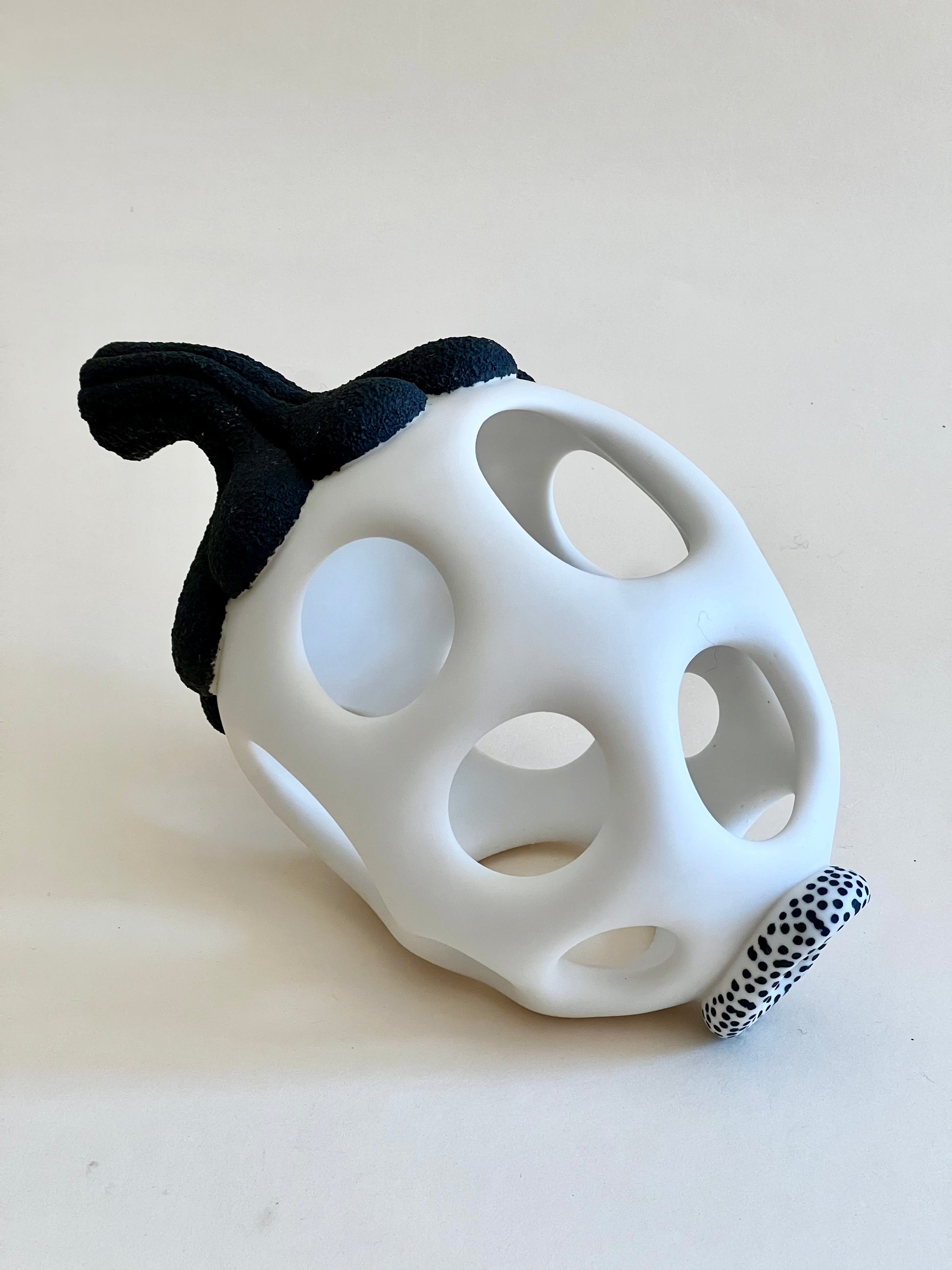 Side view of handmade pierced porcelain sculpture with organic silhouette.